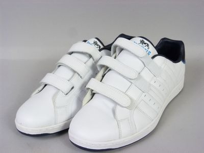 des baskets Adidas blanches avec des finitions noires et des semelles blanches sur un fond blanc