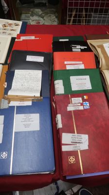 many folders of papers on a table with a red table cloth