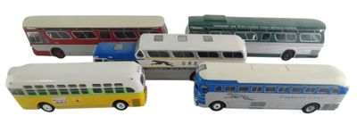 quatre petits bus qui sont rangés les uns à côté des autres