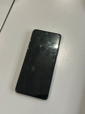 un téléphone portable noir posé sur une table blanche