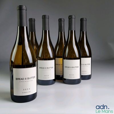 six bottles of bread and butter wine lined up on a table
