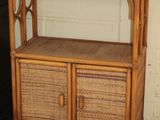 a bamboo shelf with two drawers and a cabinet in the corner