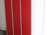a red and white locker in the corner of a room