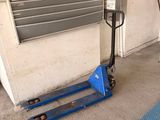 a man that is standing next to a fork lift