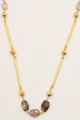 a gold plated necklace with labradorite beads on a white background
