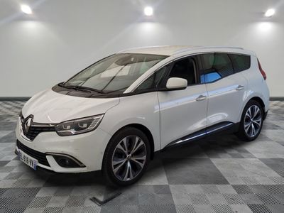 une voiture blanche garée dans un garage au sol en damier