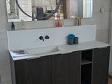 une salle de bains avec un lavabo et un miroir au mur