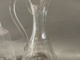 two clear glass vases sitting next to each other on a table