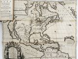 an old map of the americas with an open book on it