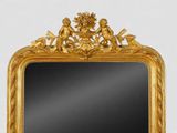 a mirror with a gold frame on a white wall