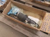 une caisse contenant une perceuse, posée sur une palette
