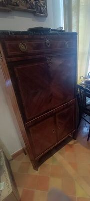 une petite table sur laquelle est posé un ordinateur portable, dans une pièce