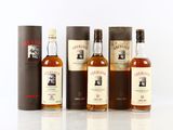 trois bouteilles de whisky sont alignées sur une surface blanche