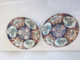 two plates with different designs on them sitting on a white surface