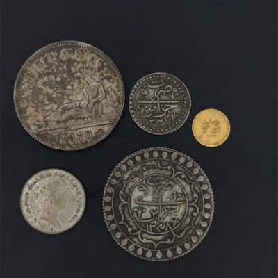 three silver and gold coins, one of which has a picture of a man on a horse, and one of which has a picture of a man on a horse