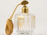 an image of a glass perfume bottle with a gold handle