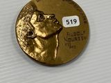 a close up of a gold coin with a dog on it