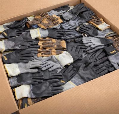 une boîte en carton remplie de nombreux gants, posée sur une table