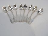 six silver spoons are lined up in a row on a white surface