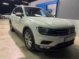 a white volkswagen tigua parked in a parking lot