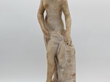 a statue of a boy holding a bag on a white surface