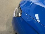 a close up of a blue car parked on the street