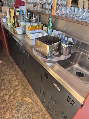 a kitchen with a sink and a lot of wine glasses on the counter