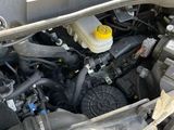 a car engine with the hood open and a yellow bottle in it