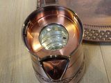 a small copper pot sitting on a table next to a tray