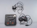 une console de jeux vidéo et une manette de jeu placées l'une à côté de l'autre
