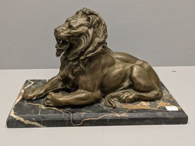 statue of a lion on a marble base on a table