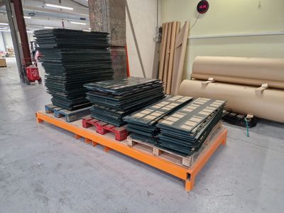 de nombreux rouleaux de papier sur une palette dans un entrepôt