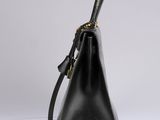 a black leather handbag with gold hardware on the handle