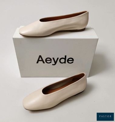 une paire de chaussures blanches posée sur une boîte blanche