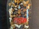 une cloche en verre contenant un objet rouge