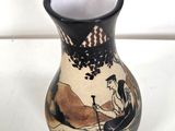 a black and white vase with a painting on it