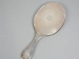 an antique silver spoon with a handle on a white surface