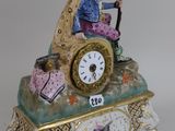 a figurine of a man riding a carriage with a clock on it