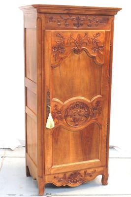 une armoire en bois surmontée d'une cloche