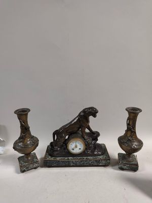 trois vases et une horloge posés sur une table