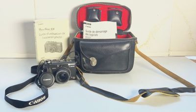 un appareil photo noir et un sac noir posés sur une table