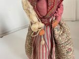 a figurine of an old woman holding a bag