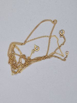 un collier en or auquel est attachée une chaîne