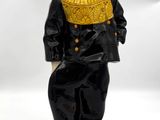 figurine représentant un garçon vêtu d'un costume noir et d'un col jaune