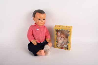 une poupée assise à côté d'une boîte contenant une poupée