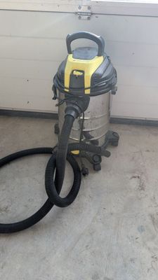 un aspirateur posé sur le sol à côté d'un tuyau