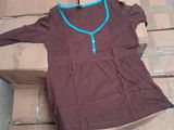 a brown shirt with a blue zipper on it sitting on a pile of boxes
