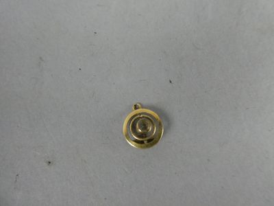 gros plan d'un objet en métal doré sur une surface blanche