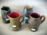 trois vases posés l'un à côté de l'autre sur une table