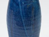 a blue vase that is sitting on a white surface